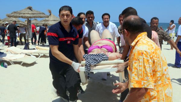 Tunisian medics carry a woman on a stretcher in the resort town of Sousse after an IS-related attack on June 27, 2015. The attack killed nearly 40 people, most of them British tourists. (AFP)