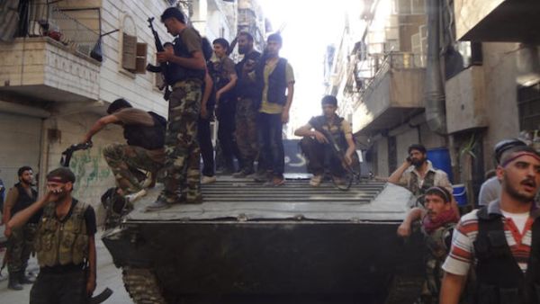 Syrian rebel fighters gather around a former Syrian army tank as rebels prepare to attack positions held by the Syrian army areas in the Salaheddine neighborhood of Aleppo, on July 8, 2013 (Source: AFP/ABO MHIO)