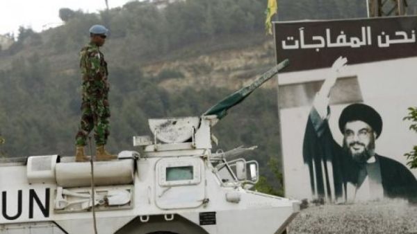 A UN peacekeeper is seen near Lebanon's Blue Line, with a picture of the Hezbollah leader Hassan Nasrallah in the background. (AFP/File)