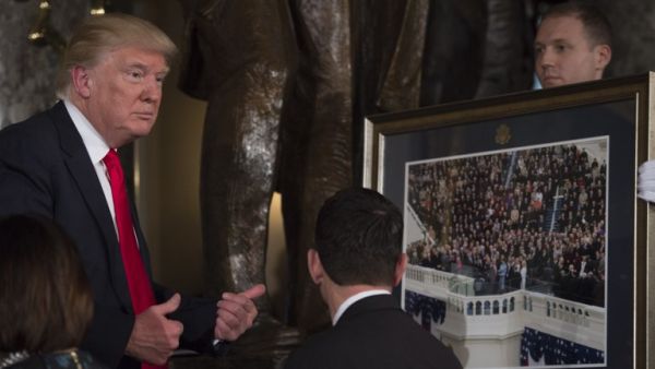 US President Donald Trump gives a thumbs up in front of House Speaker Paul Ryan after being presented a photo of his inauguration during the Inaugural Luncheon following his inauguration as the 45th President of the United States, in Washington, DC, on January 20, 2017. (AFP/Molly Riley)