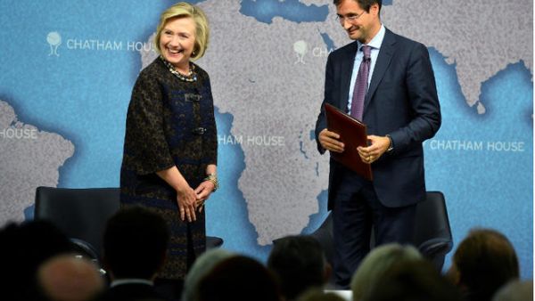 Former US secretary of state Hillary Clinton and director of Chatham House Robin Niblett (R) arrive for a discussuion session at Chatham House in central London on October 11, 2013. (Image credit: AFP)