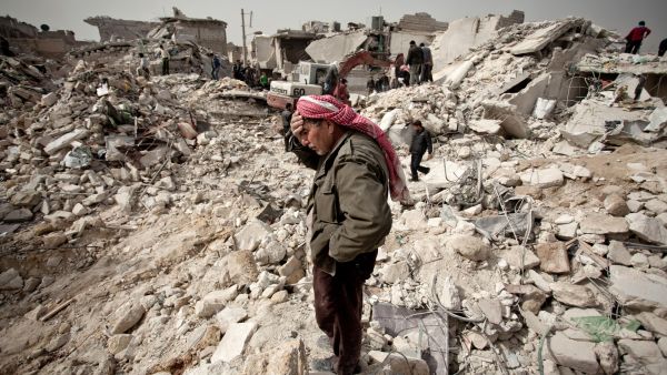 A Syrian man stands over the rubble of his house in Aleppo on February 23, 2013.  (AFP/Pablo Tosco)
