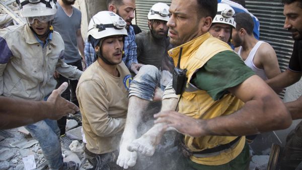 White Helmets rescue a child after a strike in Syria (AFP/FILE)