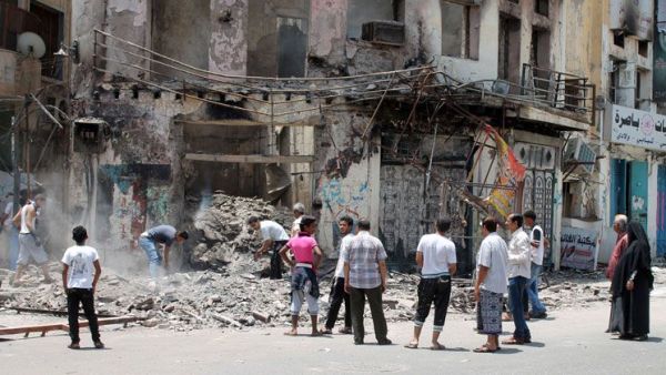 Yemeni people inspect the damage to a building in Aden. Image used for illustrative purposes. (Al Bawaba/File)
