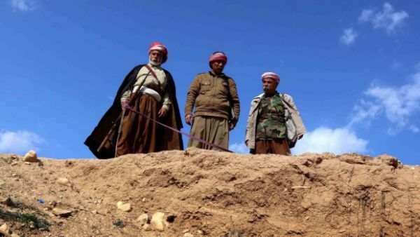 Yazidi men overlook a mass grave of Yazidi victims killed by Daesh. (AFP/File) 