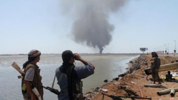 Pro-Hadi government loyalists in Yemen watch as smoke rises from an explosion in Sanaa. (AFP/File)