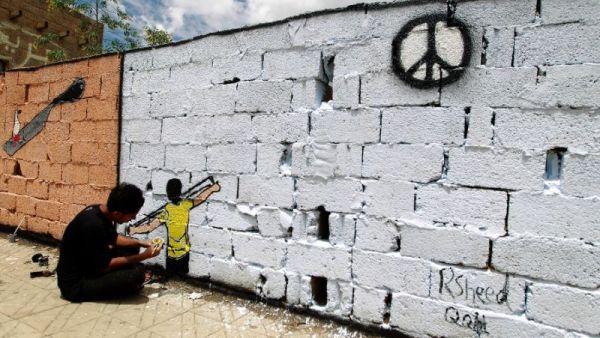 A Yemeni artist paints a wall in the capital Sanaa with a message of peace.  (AFP/File)