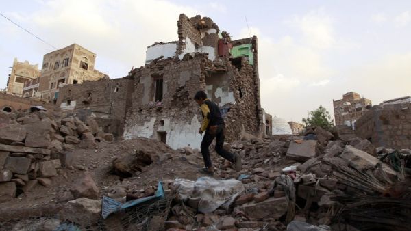 A file photo of a Yemeni boy walking through the rubble of a Saudi-led airstrike on Sanaa. (AFP/Mohammed Huwais)