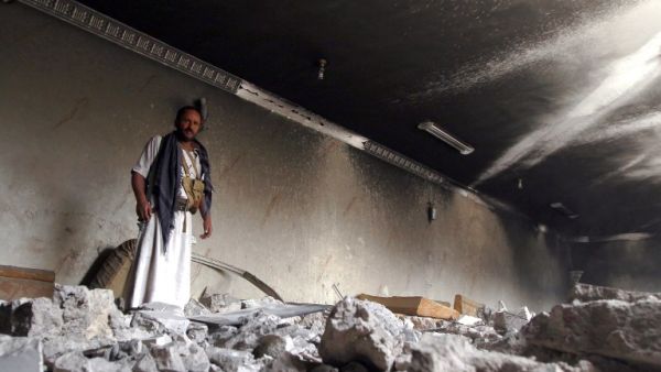 A Yemeni armed man stands amidst the debris of a house destroyed in an air-strike by the Saudi-led coalition in the capital Sanaa on July 6, 2015. (AFP/Mohammed Huwais)