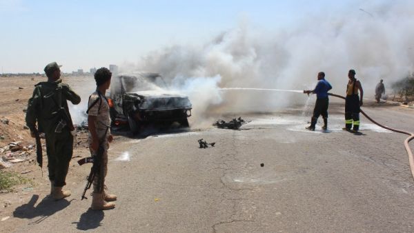 Yemeni security forces extinguish fire at a site where a bomb-laden car exploded in Aden's Mansura district on May 1, 2016. (AFP/Saleh al-Obeidi)