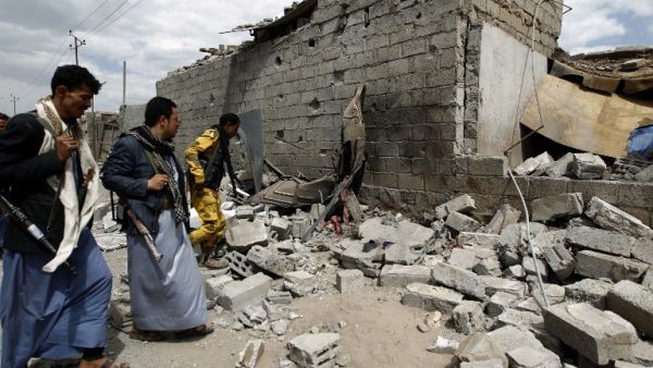 Yemeni men walk amid the ruins of a building in Yemen's Houthi rebel-held capital Sanaa on August 29, 2016, after it was reportedly hit by a Saudi-led coalition air strike. (AFP/Mohammed Huwais)