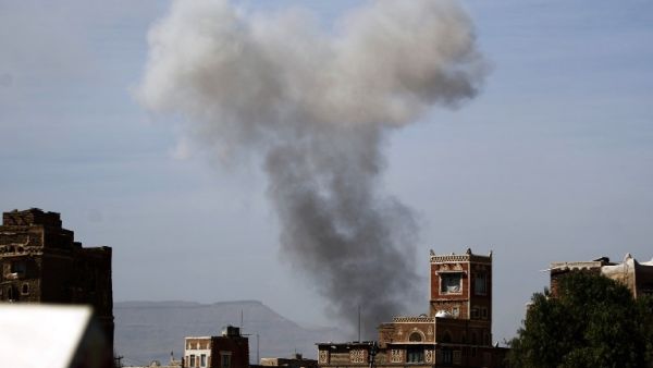 Smoke billows behind a building following a reported air strike by the Saudi-led coalition in the Yemeni capital Sanaa on January 22, 2017. (AFP/Mohammed Huwais)