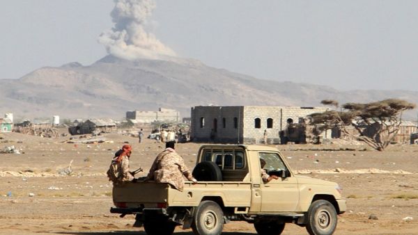 Smoke billows in the distance as Yemeni pro-government forces patrol during clashes with Houthi rebels in Yemen's western Dhubab district, on January 9, 2017. (AFP/Saleh al-Obeidi)