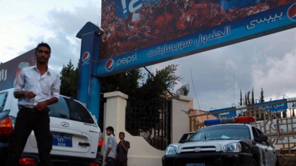 Yemeni policemen and people gather at the scene where the bodyguard of Germany's ambassador to Yemen was killed in the southern Sanaa district of Hada. (Image credit: AFP)