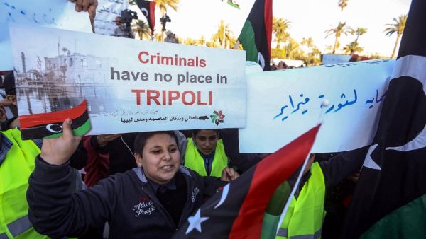 A Libyan youth holds up a protest sign during a demonstration against strongman Khalifa Haftar in the capital Tripoli's Martyrs Square on April 12, 2019.  Mahmud TURKIA / AFP