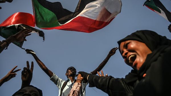 Sudanese protesters chant slogans and wave the national flag during a sit-in outside the army headquarters in the capital Khartoum  (AFP)
