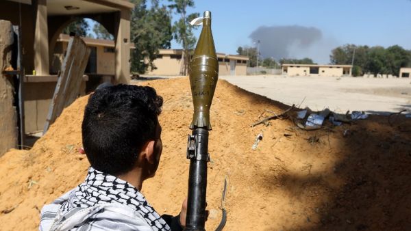 A fighter loyal to the internationally recognised Libyan Government of National Accord (GNA) holds a rocket propelled grenade launcher as he keeps position (AFP)
