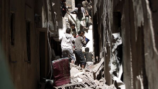 Yemenis sift the rubble of a heavily damaged building following reported Saudi-led coalition air strikes in the Yemeni capital Sanaa (AFP)