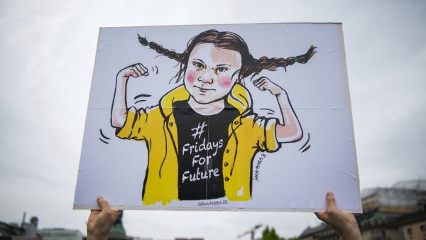 A protester holds up placard depicting the 16-year-old Swedish climate activist Greta Thunberg  (AFP)
