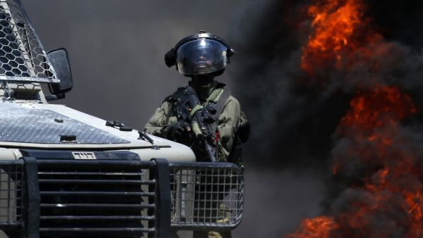 A member of the Israeli forces looks on during clashes with Palestinian protesters (AFP)