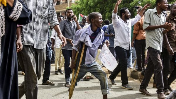 A Sudanese protester walking with a crutch joins others in a march during a mass demonstration against the country's ruling generals in the capital Khartoum's twin city of Omdurman on June 30, 2019.  Ahmed MUSTAFA / AFP