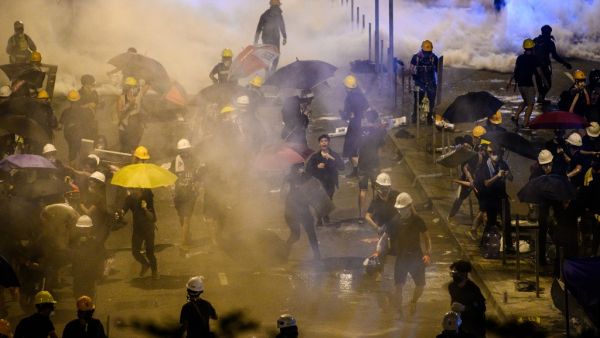 Police fire tear gas at protesters near the government headquarters in Hong Kong  (AFP)
