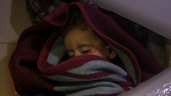 The body of a Syrian infant lies at a morgue following reported regime airstrikes on the town of Muhambal, in the northern Idlib province (AFP)