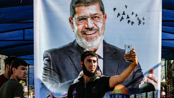 Egyptian youth wait outside a courthouse in which former Egyptian President Mohammed Morsi is on trial /AFP