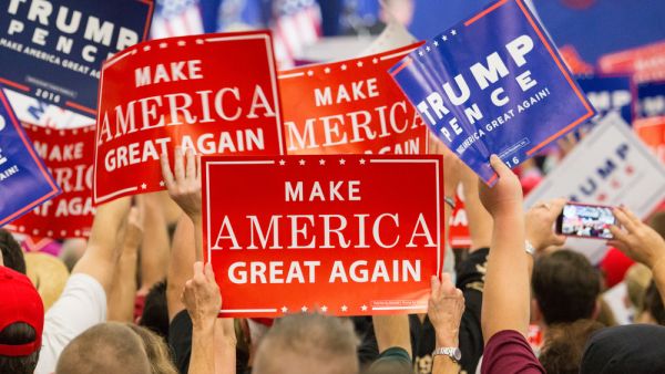 Manheim, PA - October 1, 2016: People enthusiastically wave Make America Great Again Signs at a Donald Trump campaign rally.