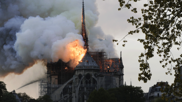 Flames and smoke are seen billowing from the roof at Notre-Dame Cathedral in Paris on April 15, 2019. A fire broke out at the landmark Notre-Dame Cathedral in central Paris, potentially involving renovation works being carried out at the site, the fire service said.