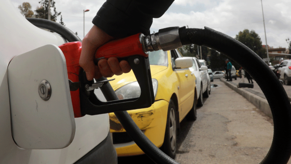 A driver fills his car with gasoline after queueing in front of a petrol station in the Syrian capital Damascus. 