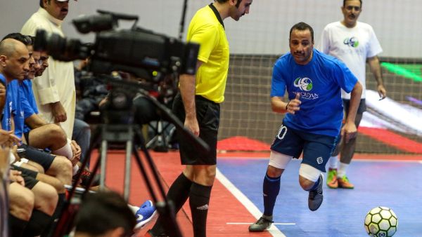 Kuwaiti Parliament Speaker Marzouq al-Ghanim (R) fights for the ball during a friendly indoors football match between members of Kuwait's cabinet and parliament in Kuwait City on May 18, 2019. 