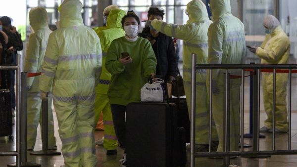 Medical workers wearing protective clothing check passengers' travel history at the Shanghai South railway station in Shanghai on February 9, 2020. AFP