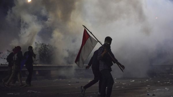 Students try to take cover as police shoot tear gas during a protest outside the parliament building in Jakarta on September 30, 2019. (AFP/ File Photo)