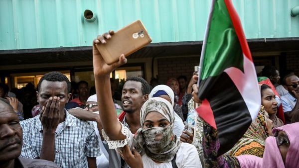 Sudanese demonstrators welcome fellow protesters from the city of Atbara with cheers and national flags as their train arrives at the Bahari station in Khartoum on April 23, 2019. OZAN KOSE / AFP