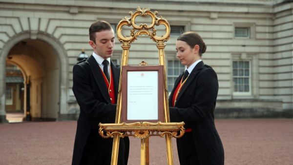 Footmen Stephen Kelly and Sarah Thompson set up an official notice on an easel at the gates of Buckingham Palace in London on May 6, 2019, announcing the birth of a son to Britain's Prince Harry, Duke of Sussex and Meghan, Duchess of Sussex. (AFP/ File Photo)