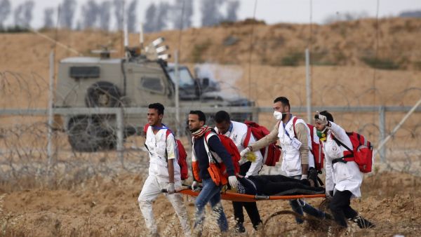 Palestinian paramedics carry a man on a stretcher during a demonstration near the border with Israel, east of Khan Yunis in the southern Gaza Strip, on April 26, 2019. (Said KHATIB / AFP)