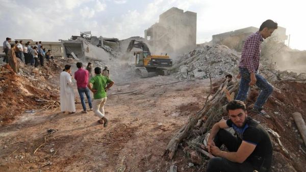 Syrians gather amid destruction in Zardana, in the northern Syrian Idlib province. (AFP/ File Photo)