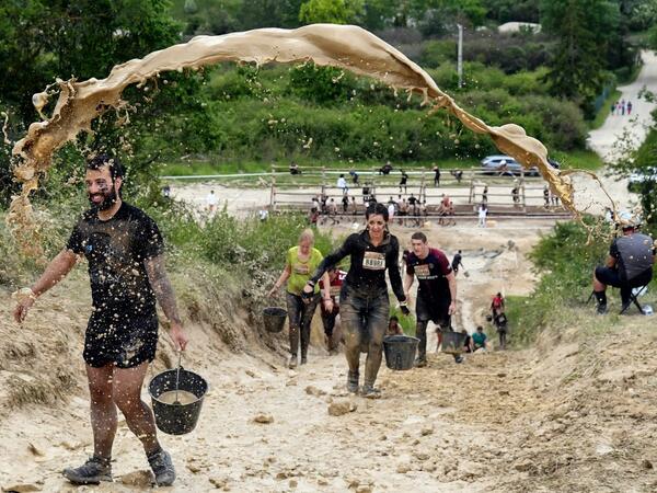 Mud is thrown at runners as they take part in the Mud Day, a 13km race with obstacles in Beynes, near Paris on June 16, 2019.  ALAIN JOCARD / AFP