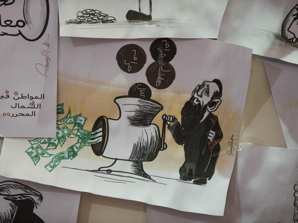 This picture taken on June 16, 2019, shows various illustrations by Syrian Cartoonist Amani al-Ali at her home studio in the city of Idlib in the eponymous northwestern province.  Omar HAJ KADOUR / AFP