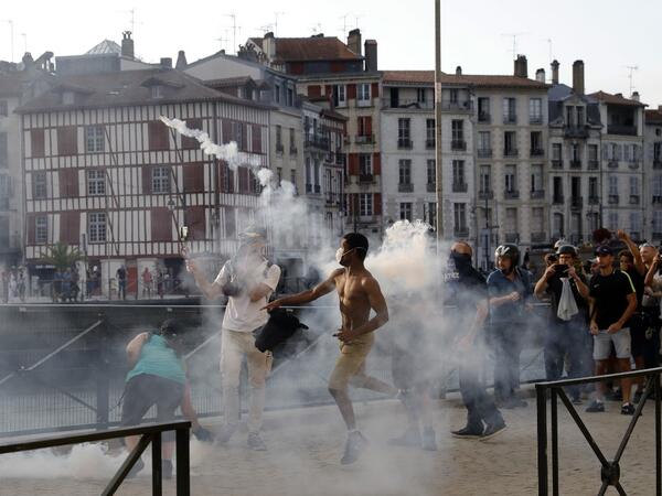 A protester lobs a 'canister' back towards French security personnel during a demonstration in the city of Bayonne, south-west France on August 24, 2019, on the sidelines of the annual G7 Summit. Thomas SAMSON / AFP