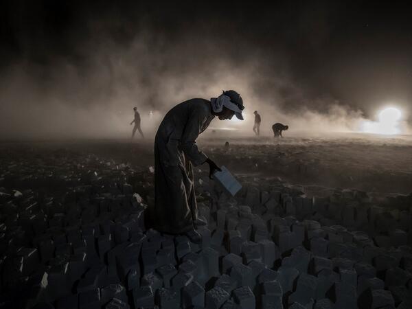 A labourer carries a stone block while working late at the "White Mountain" limestone extraction quarry site near Egypt's southern city of Minya, some 265 kilometres south of the capital, on November 13, 2019. Covered in fine white dust, labourers at the so-called "White Mountain" off Minya toil in shifts amidst brutal conditions with little workplace safety for paltry pay. They handle dangerous machinery with finesse, and shrug off the dangers of a job where a mistake can prove fatal. Khaled DESOUKI / AFP