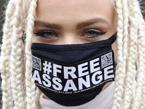 Nina from Amsterdam, a supporter of WikiLeaks founder Julian Assange, wears a face mask called for Assange's freedom as she poses for a photograph outside Woolwich Crown Court in southeast London on February 24, 2020, on the day of the opening of the full hearing into a US request for Assange's extradition. A British court on February 24 starts hearing Washington's extradition request for WikiLeaks founder Julian Assange in a test case of media freedoms in the digital age and the global limits of US justice