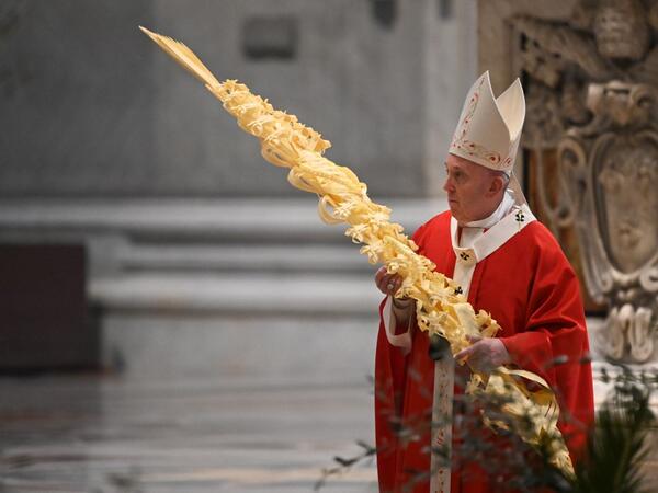 Pope Francis holds a palm branch as he celebrates Palm Sunday mass behind closed doors at St. Peter's Basilica mass on April 5, 2020 in The Vatican, during the lockdown aimed at curbing the spread of the COVID-19 infection, caused by the novel coronavirus. Alberto PIZZOLI / POOL / AFP