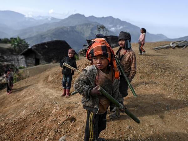 This photo taken on February 9, 2020 shows children playing in Karmawlawyi village in Myanmar's Sagaing region, near the border with India. The king of the Konyak tribe sleeps in Myanmar, but eats in India -- his house, village and people divided by a mountain border which serves as a vulnerable lifeline now severed by a coronavirus lockdown.  Ye Aung THU / AFP
