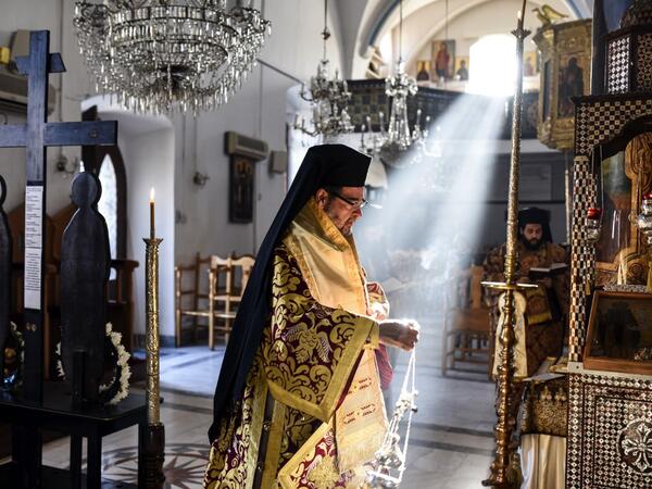 Bishop Nikodimos of Nitria, Exarch of the Patriarchate of Alexandria in Cyprus, swings an incense censer by the epitaphios (a religious icon made of an embroidered cloth used as a re-enactment of the body of Christ), during the Holy Saturday Matins at the Greek Orthodox Church of Saint Savvas in the old walled city of the Cypriot capital Nicosia on April 17, 2020, as prayers are held without a congregation due to the COVID-19 coronavirus pandemic. Amir MAKAR / AFP