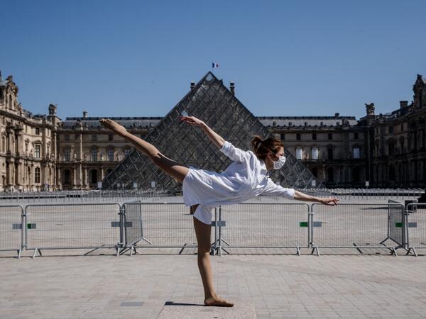Syrian dancer and choreographer Yara al-Hasbani performs a dance in front the Louvre museum pyramid in Paris on April 22, 2020, on the 37th day of a strict lockdown in France to stop the spread of COVID-19 (novel coronavirus). Yara al-Hasbani was putting the finishing touches to her make-up for a performance of "Romeo and Juliet" in Damascus when she found out her father had been tortured to death. Sameer Al-DOUMY / AFP