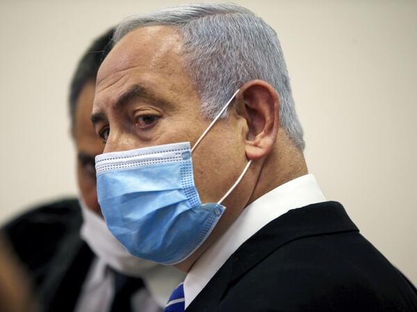 Israeli Prime Minister Benjamin Netanyahu, wearing a protective face maks, is pictured inside a courtroom at the district court of Jerusalem on May 24, 2020, during the first day of his corruption trial. Fresh from forming a new government after more than 500 days of electoral deadlock, Netanyahu is expected to begin a new battle in the Jerusalem District Court -- to stay out of prison. The 70-year-old was scheduled to appear at a court hearing to formally confirm his identity to judges, after being indicte