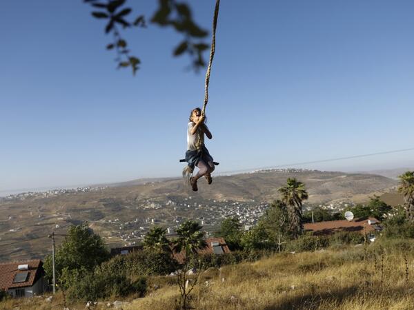 A girl swings at a park in the Israeli Yitzhar settlement south of the Palestinian city of Nablus in the occupied the West Bank on June 22, 2020. The government of Israeli Prime Minister Benjamin Netanyahu has said it could begin the process to annex Jewish settlements in the West Bank as well as the strategic Jordan Valley from July 1.The plan -- endorsed by Washington -- would see the creation of a Palestinian state, but on reduced territory, and without Palestinians' core demand of a capital in east Jeru