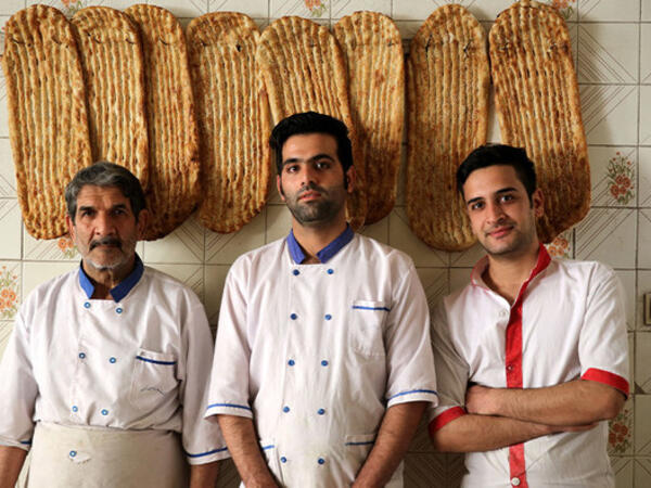 Iranian bakers Esmail Asghari, 66, Farzad Rabiei, 30, and Mojtaba Haydari, 23, pose with Barbari bread in Tehran on June 7, 2020. ATTA KENARE / AFP